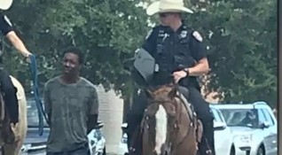 Снимки на двама бели конни полицаи водещи чернокож мъж вързан