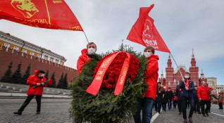 Малка група руски комунисти носещи защитни маски и червени знамена