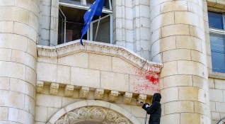 Работници почистват червена боя от фасадата на Съдебната палата хвърлена