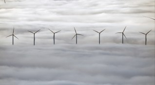 Вятърни генератори се издигат на есенната мъгла край испанския град