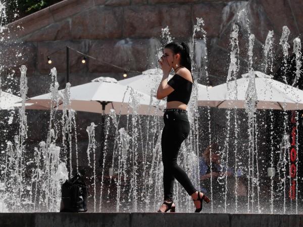 Младо момиче се разхлажда край фонтан в Киев. Снимка: БГНЕСПо